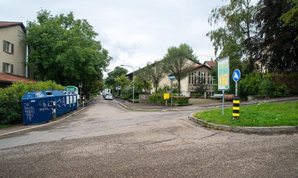 Colour coded recycling bins line a quiet residential street on collection day.