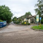 Colour coded recycling bins line a quiet residential street on collection day.