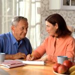Senior couple reviewing household finances together at a kitchen table