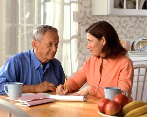 Senior couple reviewing household finances together at a kitchen table