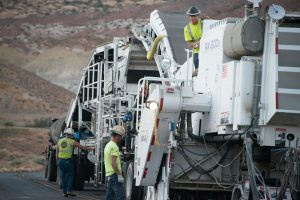 workers resurfacing a road with fresh asphalt