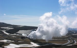 Steam rising from a geothermal power plant in a volcanic landscape